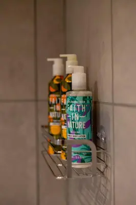 a shelf in a bathroom with lots of bottles of paint at Judith House in Shrewsbury