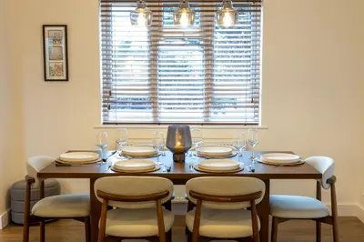 a dining room table with chairs and a large window at Judith House in Shrewsbury
