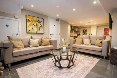 a living room with two couches and a glass table at Fantastic 6-bedroom house close to Shrewsbury town - Pass the Keys in Shrewsbury