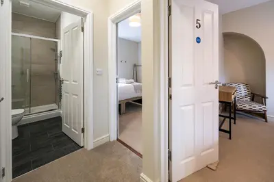 a bathroom with a door leading to a bedroom at Fantastic 6-bedroom house close to Shrewsbury town - Pass the Keys in Shrewsbury