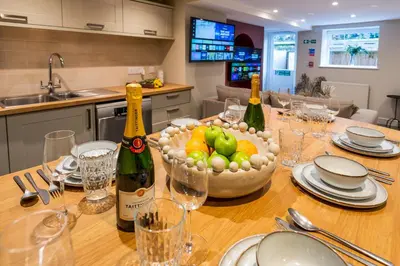 a table with two bottles of champagne and a bowl of fruit at Fantastic 6-bedroom house close to Shrewsbury town - Pass the Keys in Shrewsbury