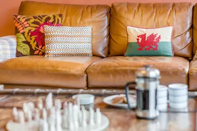 a brown leather couch with pillows and a chessboard at 5 Bed in Llangollen oc-l34205 in Llangollen