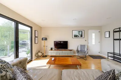 a living room with a couch and a table at Luxury Lakeside Lodge with Hot Tub in Ratlinghope in Ratlinghope