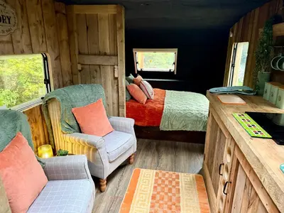 a bedroom with a bed and a couch and a chair at Nesta's Nook in Llandovery