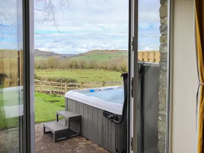a jacuzzi tub in a room with a window at Towy Cottage - Uk49589 in Llansawel