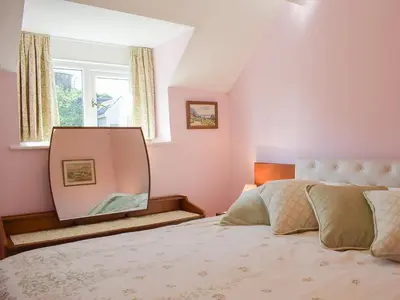a bedroom with a mirror and a bed at Canon's Cottage in Clun