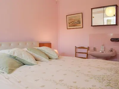 a bedroom with a bed with pillows and a sink at Canon's Cottage in Clun
