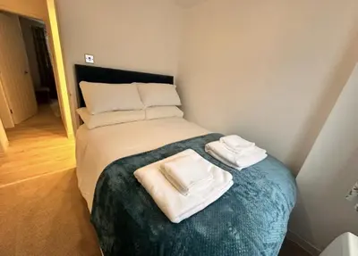 a small bed with two towels on top of it at Pet friendly 3 bed retreat for beach, castle, golf in Harlech