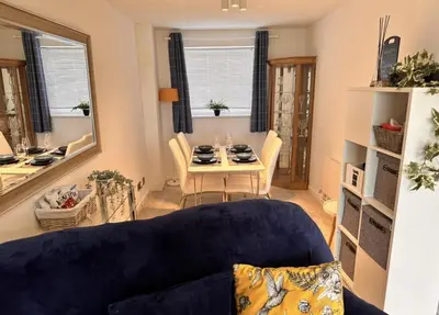 a living room with a blue couch and a table at Pet friendly 3 bed retreat for beach, castle, golf in Harlech