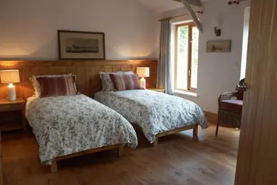 a bedroom with two beds and a window at Alder Barn in Clun
