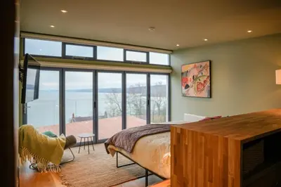a bedroom with a bed and a view of the ocean at Y Llofft in New Quay