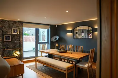 a dining room with a wooden table and chairs at Y Llofft in New Quay
