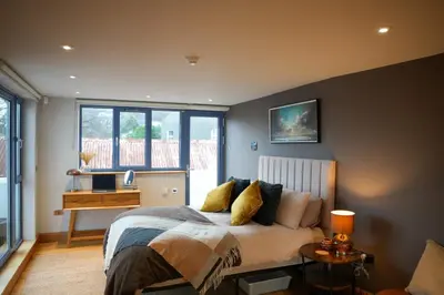 a bedroom with a bed and a desk in it at Y Llofft in New Quay
