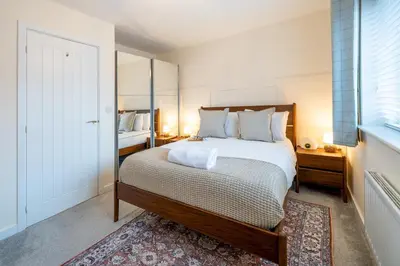 a bedroom with a large bed and a mirror at Cosy & Contemporary 2 Bed Home, Quiet Area Parking - Pass the Keys in Shrewsbury