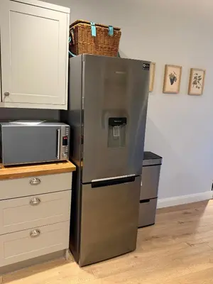 a stainless steel refrigerator in a kitchen with a microwave at Unique Vicarage Town Cottage in Leominster