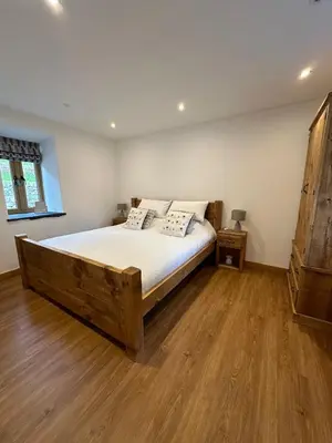 a bedroom with a wooden bed and a wooden floor at Y Sgubor Bryn Banon in Bala