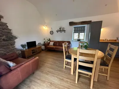 a living room with a table and a couch at Y Sgubor Bryn Banon in Bala