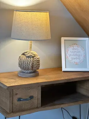 a lamp on top of a table with a picture at Y Beudy Bach in Llanfor