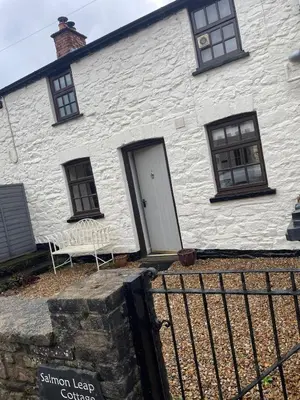 a white house with a white door and windows at Cosy River Cottage in Brecon with a Fireplace in Merthyr Cynog