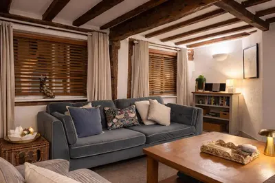 a living room with a blue couch and a table at Cosy Town centre Historic Tudor Cottage & parking sleeps 6 in Shrewsbury