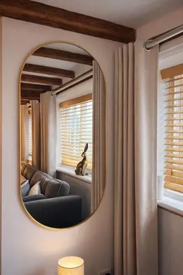 a living room with a mirror and a couch at Cosy Town centre Historic Tudor Cottage & parking sleeps 6 in Shrewsbury