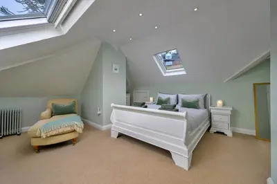 a bedroom with a bed and a chair in a attic at Finest Retreats - Bryn Awelon in Harlech