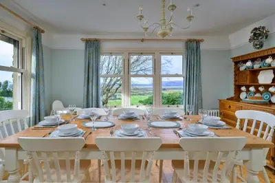 a dining room with a wooden table and chairs at Finest Retreats - Bryn Awelon in Harlech