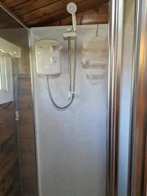 a shower in a bathroom with a glass door at Cabin Retreat in Trawsfynydd