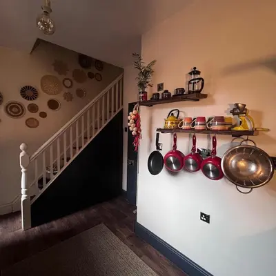 a kitchen with pots and pans on a wall at Cosy, quirky Victorian house on Waterfall Street in Llanrhaeadr-ym-Mochnant