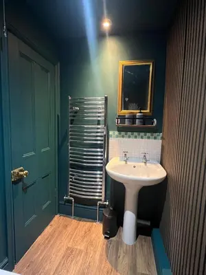 a bathroom with a sink and a mirror at Cosy, quirky Victorian house on Waterfall Street in Llanrhaeadr-ym-Mochnant