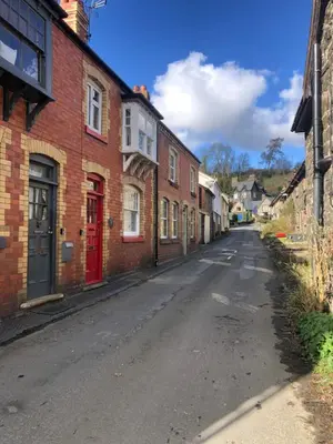 an empty street in a town with brick buildings at Cosy, quirky Victorian house on Waterfall Street in Llanrhaeadr-ym-Mochnant