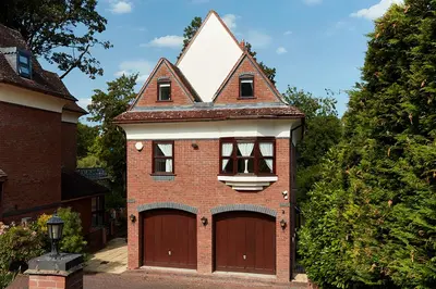 a small brick house with two garage doors at Ever popular 2 bedroom riverside home - to sleep 4 - Pass the Keys in Shrewsbury