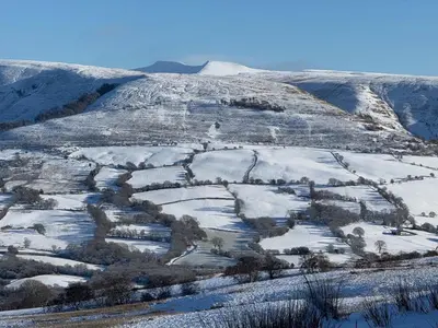 a snow covered hillside with a field in the foreground at Y Beudy - A Converted Barn in the Brecon Beacons in Brecon