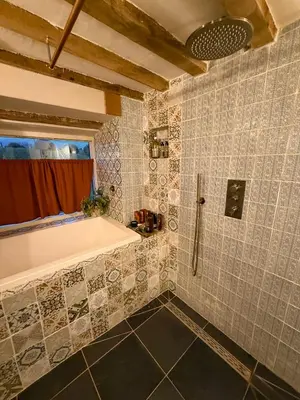 a bathroom with a shower and a tub and a bath tub at Y Beudy - A Converted Barn in the Brecon Beacons in Brecon