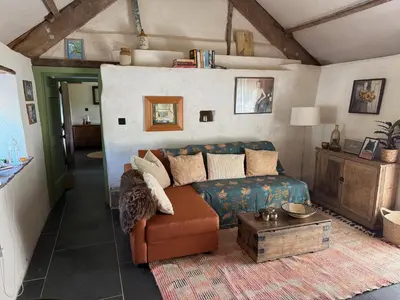 a living room with a couch and a table at Y Beudy - A Converted Barn in the Brecon Beacons in Brecon