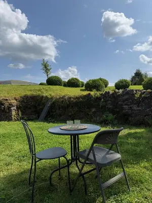 a table and two chairs sitting in the grass at Y Beudy - A Converted Barn in the Brecon Beacons in Brecon