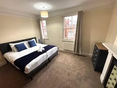 a bedroom with a bed with blue and white pillows at Victorian House in Cherry Orchard, Close to Town in Shrewsbury