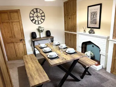a dining room with a table and a fireplace at Victorian House in Cherry Orchard, Close to Town in Shrewsbury