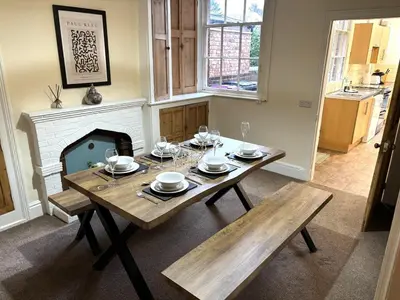 a dining room with a table and a fireplace at Victorian House in Cherry Orchard, Close to Town in Shrewsbury
