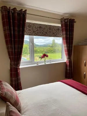 a bedroom with a bed and a window with a view at Rosehill annexe in Knighton
