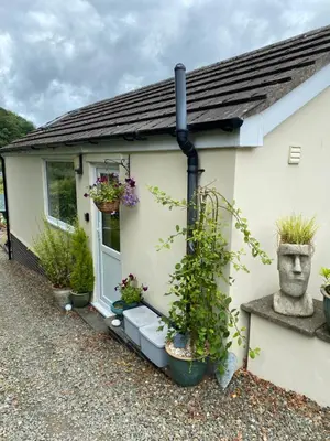 a house with potted plants on the side of it at Rosehill annexe in Knighton