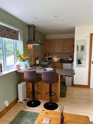 a kitchen with a counter and stools in it at Rosehill annexe in Knighton