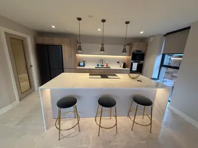a kitchen with two bar stools and a kitchen island at 3 Bed Spacious Luxury Duplex - Shrewsbury Town Centre in Shrewsbury