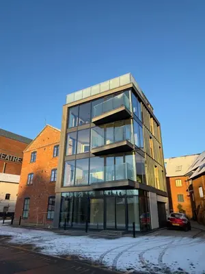 a large glass building with a car parked in front of it at 3 Bed Spacious Luxury Duplex - Shrewsbury Town Centre in Shrewsbury