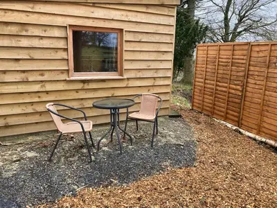 two chairs and a table in front of a house at Bijou Cabin in Ludlow