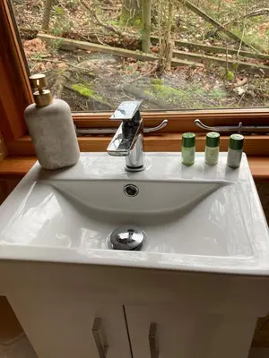 a bathroom sink with two candles and a window at Bijou Cabin in Ludlow