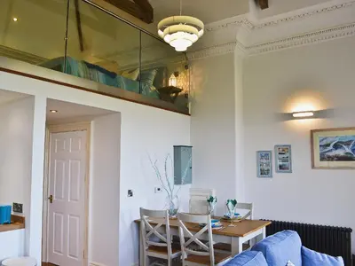 a living room with a blue couch and a table at Sea View in Rhyd-y-felin