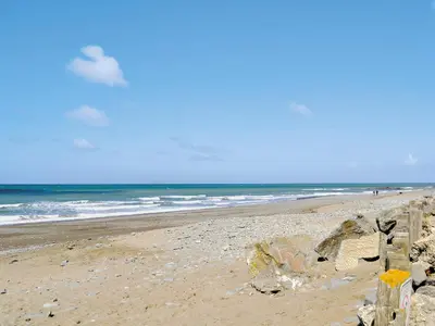 a beach with a fence and the ocean at Awel Y Mynydd - Mountain Breeze in Strata Florida