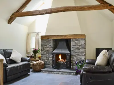a living room with a stone fireplace at Awel Y Mynydd - Mountain Breeze in Strata Florida