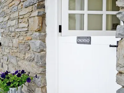 a white door with a window and a vase of flowers at Awel Y Mynydd - Mountain Breeze in Strata Florida